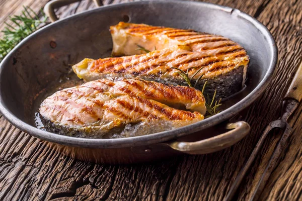 Salmon. Grilled fish salmon. Grilled  salmon steak in roasted pan on rusticc wooden table — Stock Photo, Image