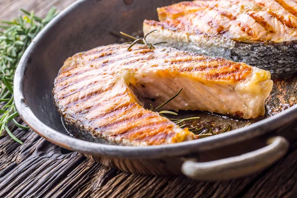Salmon. Grilled fish salmon. Grilled  salmon steak in roasted pan on rusticc wooden table — Stock Photo, Image