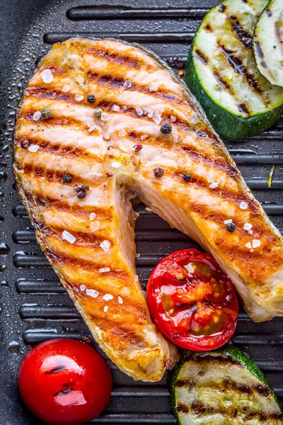 Salmon. Grilled fish salmon. Grilled  salmon steak in grill pan on rustic wooden table — Stock Photo, Image