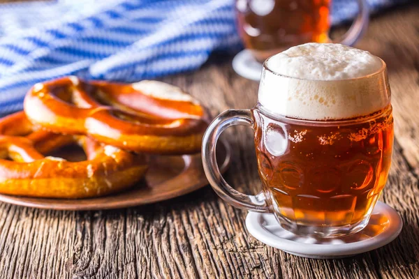 Bira ve Oktoberfest. Taslak bira simit ve mavi kareli masa örtüsü olarak Bavyera Festivali için geleneksel ürünleri oktoberfest