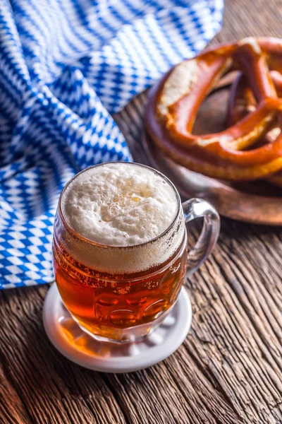 Bira ve Oktoberfest. Taslak bira simit ve mavi kareli masa örtüsü olarak Bavyera Festivali için geleneksel ürünleri oktoberfest