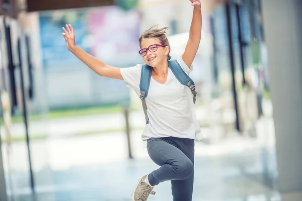 Skolflicka med väska, ryggsäck. Porträtt av modern glad tonåring skolflicka med ryggsäck. Flicka med tandställning och glasögon — Stockfoto
