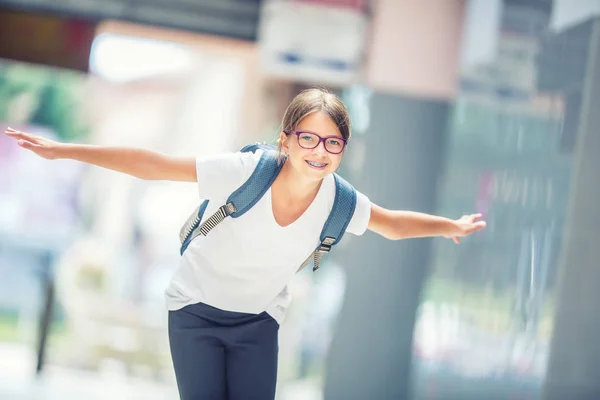 Skolflicka med väska, ryggsäck. Porträtt av modern glad tonåring skolflicka med ryggsäck. Flicka med tandställning och glasögon — Stockfoto