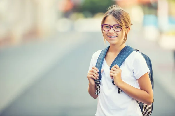 Uczennica z torba, plecak. Portret nowoczesne szczęśliwy Nastolatki uczennice z torba plecak. Dziewczyna z aparatów na zęby i okulary — Zdjęcie stockowe