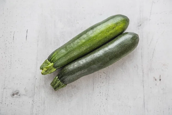 Zucchini. Fresh zucchini on white concrete board — Stock Photo, Image