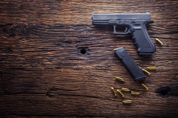 Fegyver pisztoly. 9 mm pisztoly fegyverét és golyót szétszórva a rusztikus tölgy — Stock Fotó