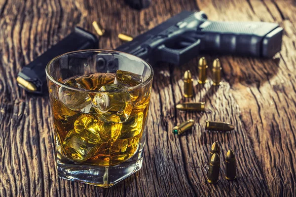 Fegyvert és az alkohol. 9mm pisztoly gun és pohár whiskey konyakos vagy brandy — Stock Fotó