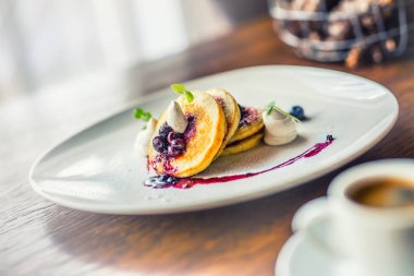 Kek ve kahve. Bir fincan kahve ve taze meyve yaban mersini ve bitki dekorasyon krep. Geleneksel kahvaltı veya bir otel ya da Restoran öğle yemeği