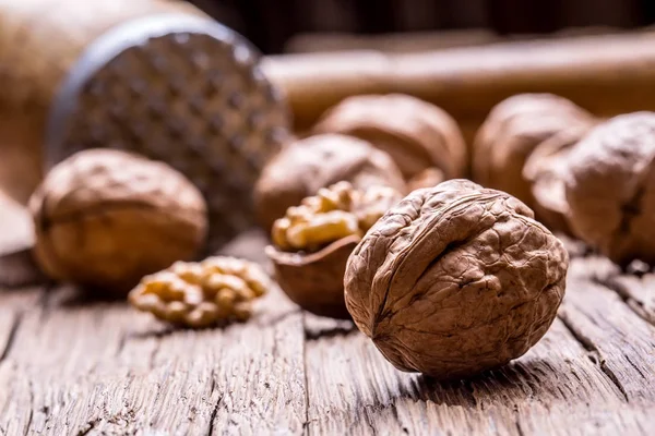 Vlašský ořech. Vlašská jádra a celé vlašské ořechy na rustikální starý dubový stůl — Stock fotografie