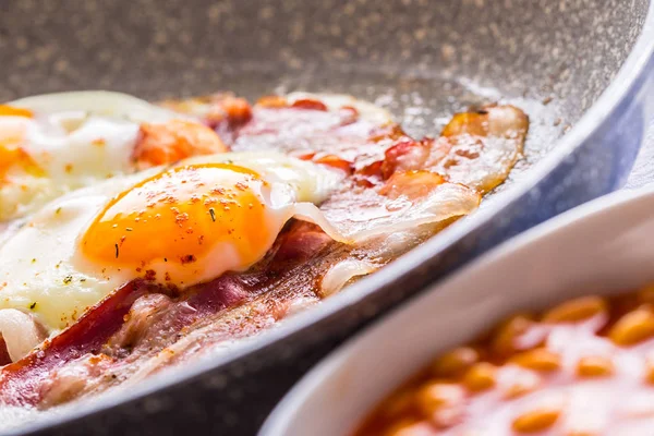 Jambon ve yumurta. Pastırmalı yumurta seramik tava kızartma. Tuzlu yumurta ve kırmızı biber serpilir. İngiliz kahvaltısı