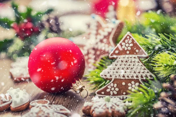 Noël. Boule de Noël pâtisserie pain d'épice cône de pin et décoration dans une atmosphère enneigée — Photo