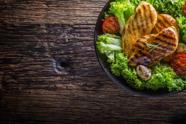 Izgara tavuk göğsü. Kavrulmuş ve ızgara tavuk göğsü marul salata domates ve mantar ile