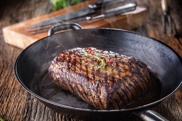 Biefstuk. Sappige Rib Eye steak in de pan op een houten bord met kruid en peper — Stockfoto