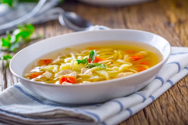 Tavuk suyu. Kemik suyu erişte havuç ve beyaz kase maydanoz ile