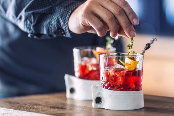 Il barista precisamente prepara la bevanda di cocktail con decorazione di erba e di frutto. Barista solo mani che preparano bevande analcoliche alcoliche — Foto Stock