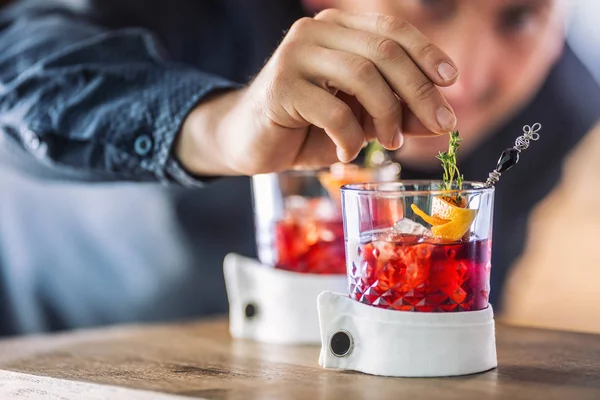 Il barista precisamente prepara la bevanda di cocktail con decorazione di erba e di frutto. Barista solo mani che preparano bevande analcoliche alcoliche — Foto Stock