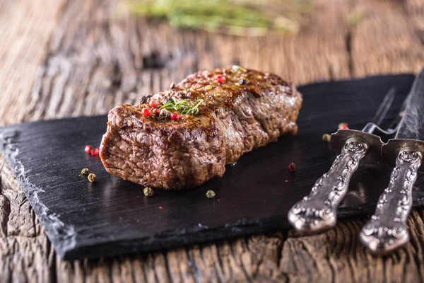 Biefstuk. Geroosterde biefstuk met zout peper tijm op rustieke houten tafel — Stockfoto