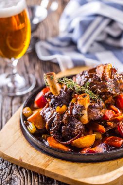 Kuzu inciği. Patates sebze ve taslak bira Bar otel ya da restoran ile Confit kuzu incik