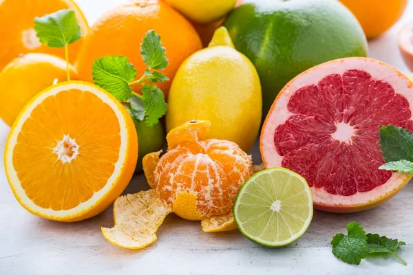 Cítricos frescos. Naranja lima limón pomelo con hojas de menta — Foto de Stock