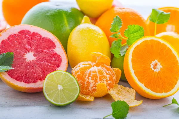 Cítricos frescos. Naranja lima limón pomelo con hojas de menta — Foto de Stock