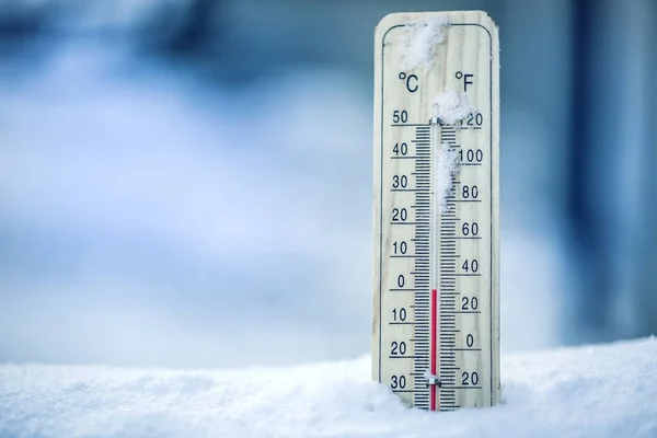 El termómetro sobre la nieve muestra las bajas temperaturas - cero. Temperaturas bajas en grados Celsius y fahrenheit. El tiempo frío invernal - cero celsius treinta y dos farenheit — Foto de Stock