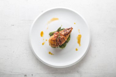 Tavuk ızgara göğsü. Pastırma ve ıspanak üzerinde beyaz plaka ile kavrulmuş tavuk göğsü