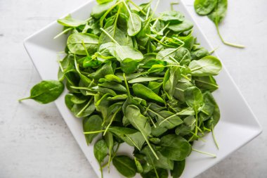 Görünümü taze ıspanak tepesine kapta beyaz beton tahtada bırakır.