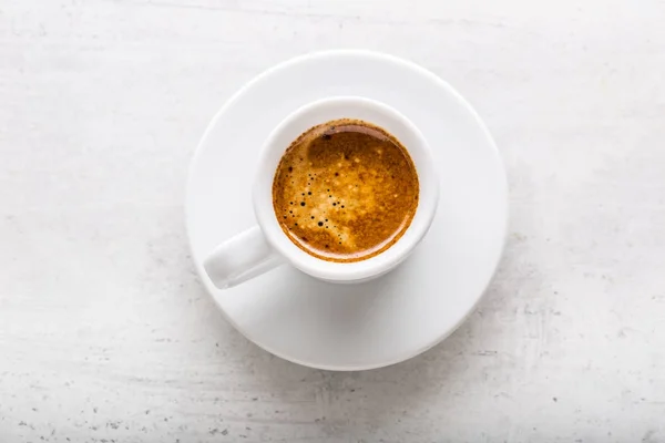 Top di vista tazza di caffè su sfondo di cemento bianco — Foto Stock
