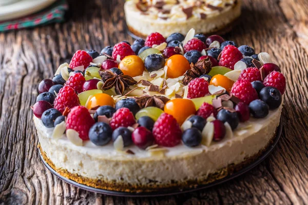 Tarta de queso con frutas frescas fresas frambuesas y anís estrellado. Tarta de queso de Navidad con decoración de Navidad — Foto de Stock