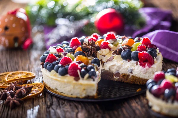 Tarta de queso con frutas frescas fresas frambuesas y anís estrellado. Tarta de queso de Navidad con decoración de Navidad — Foto de Stock