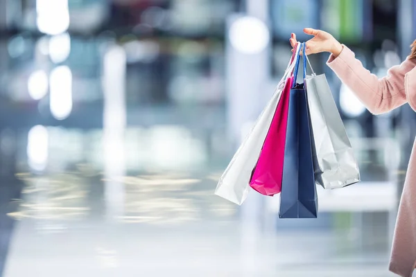 Mooi blij meisje met creditcards en shopping bags in winkelcentrum. Shopping Center op de achtergrond — Stockfoto