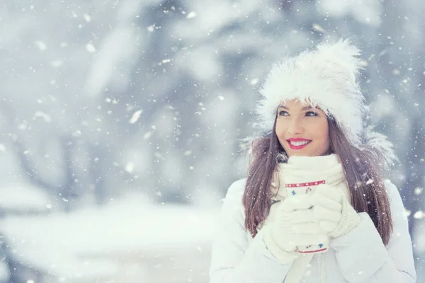Piękna, uśmiechnięta młoda kobieta w ciepłą odzież z filiżanka gorący herbata kawa lub punch. Pojęcie portret w zaśnieżonej zimy — Zdjęcie stockowe