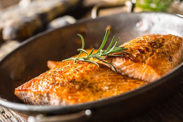 Somon balığı. İki sulu somon biftek kızartma tavada rustik meşe masada bitki dekorasyon ile — Stok fotoğraf
