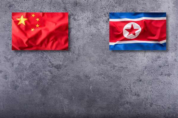 China and North korea flag on concrete background