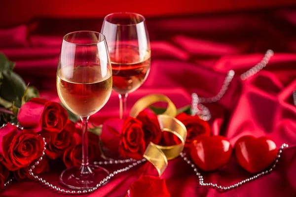 Alla hjärtans eller bröllop koncept. Vin koppar röda rosor och romantisk miljö för två i rött. Gratulationskort för jubilee eller aniversary — Stockfoto