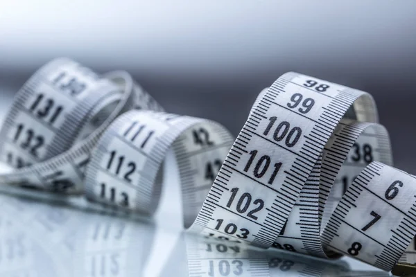 Curved measuring tape. Measuring tape of the tailor. Closeup view of white measuring tape