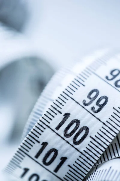 Curved measuring tape. Measuring tape of the tailor. Closeup view of white measuring tape