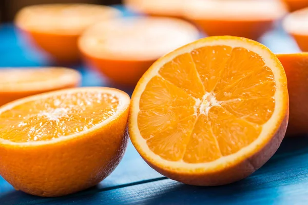 Naranja. Parte superior de la vista cortar naranjas frescas sobre una mesa azul — Foto de Stock