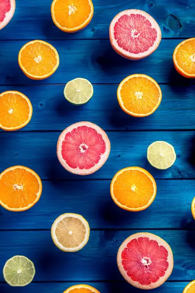 Naranjas limet limón y pomelo sobre mesa azul . — Foto de Stock