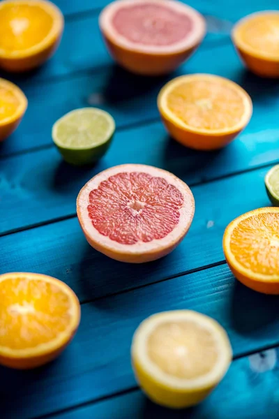 Naranjas limet limón y pomelo sobre mesa azul . — Foto de Stock