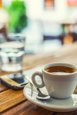 Kahve. Bir fincan kahve cep telefonu Restoran kahve evin terasında masada. Kahve molası iş