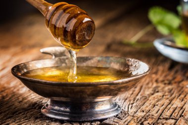 Tatlım. Bal ve bal ayı rustik meşe masada. Arka planda sıcak bitki çayı