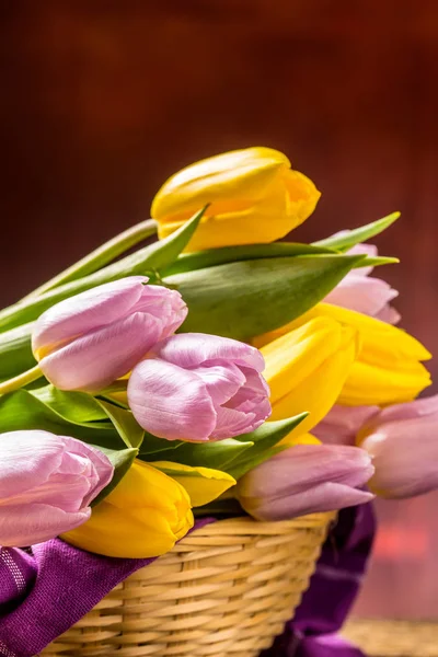 Tulipány. Kytice z jara tulipány, žluté a růžové na dřevěný stůl — Stock fotografie