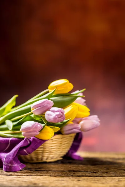 Tulipány. Kytice z jara tulipány, žluté a růžové na dřevěný stůl — Stock fotografie