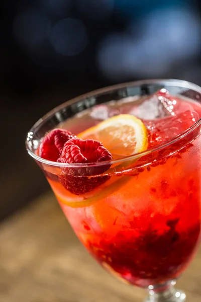 Bebida alcohólica con frambuesas limón y hielo en barra de bar — Foto de Stock