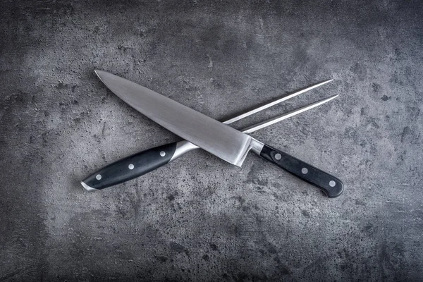 フォークとナイフ。フォークとナイフはコンクリート板の交差 — ストック写真