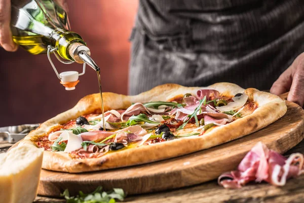 Pizza and Chef. Chef in the restaurant prepares a pizza and pour