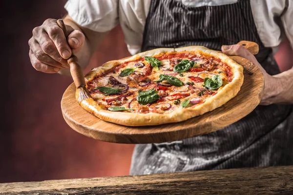 Pizza and Chef. Chef in the restaurant prepares a pizza and deco