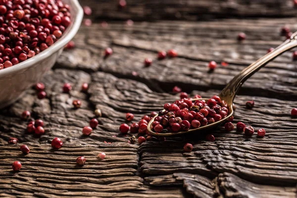 Rode peper in een kom en lepel op eiken tafel — Stockfoto