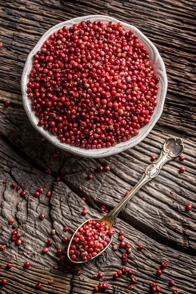 Rode peper in een kom en lepel op eiken tafel — Stockfoto